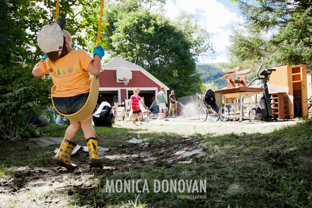 A child swings as his family empties the contents of their house in Waterbury Center, Vermont, the day after Irene swept through.